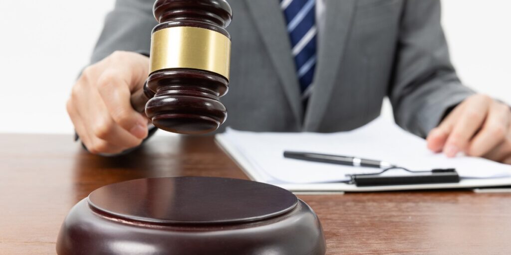 Primo piano parziale di un giudice con il martelletto in mano