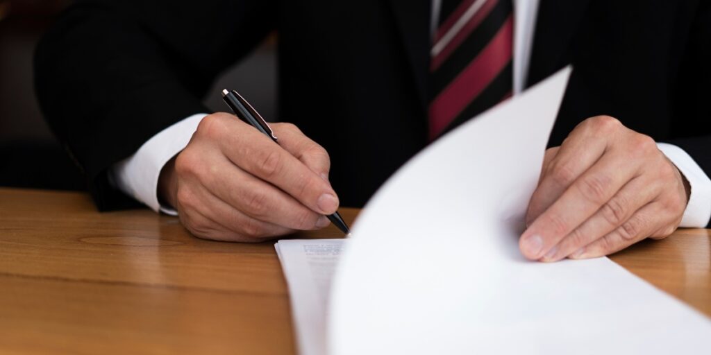 Vista frontale parziale di un uomo d’affari che scrive su un foglio